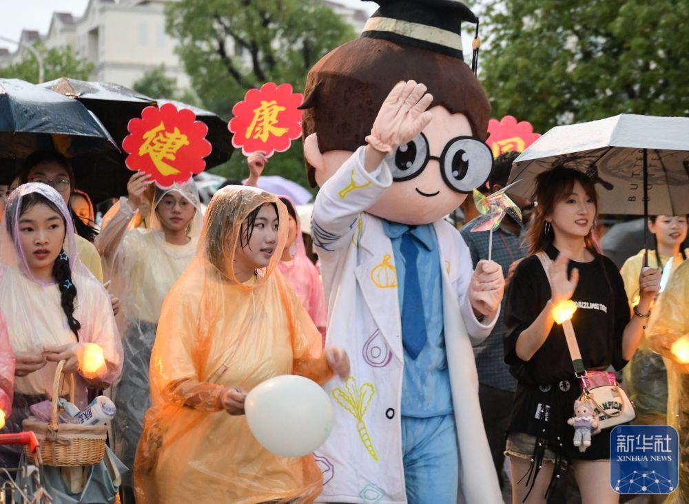 6月21日，老版新葡萄8883国际官网学生在校园里冒雨巡游。2